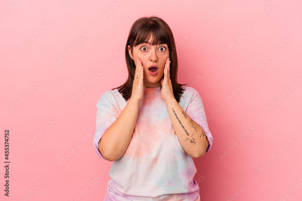 Young curvy caucasian woman isolated on pink background having fun covering half of face with palm. Young curvy caucasian woman isolated on pink background having fun covering half of face with palm.