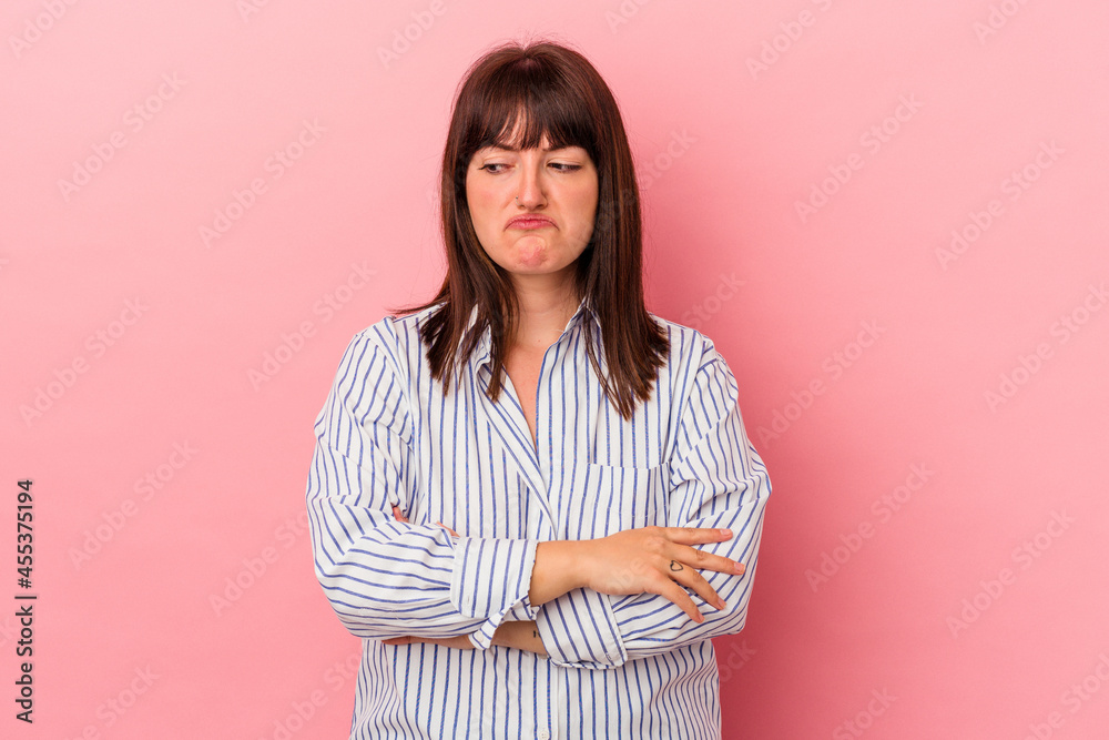 Young curvy caucasian woman isolated on pink background tired of a repetitive task. Young curvy caucasian woman isolated on pink background tired of a repetitive task.