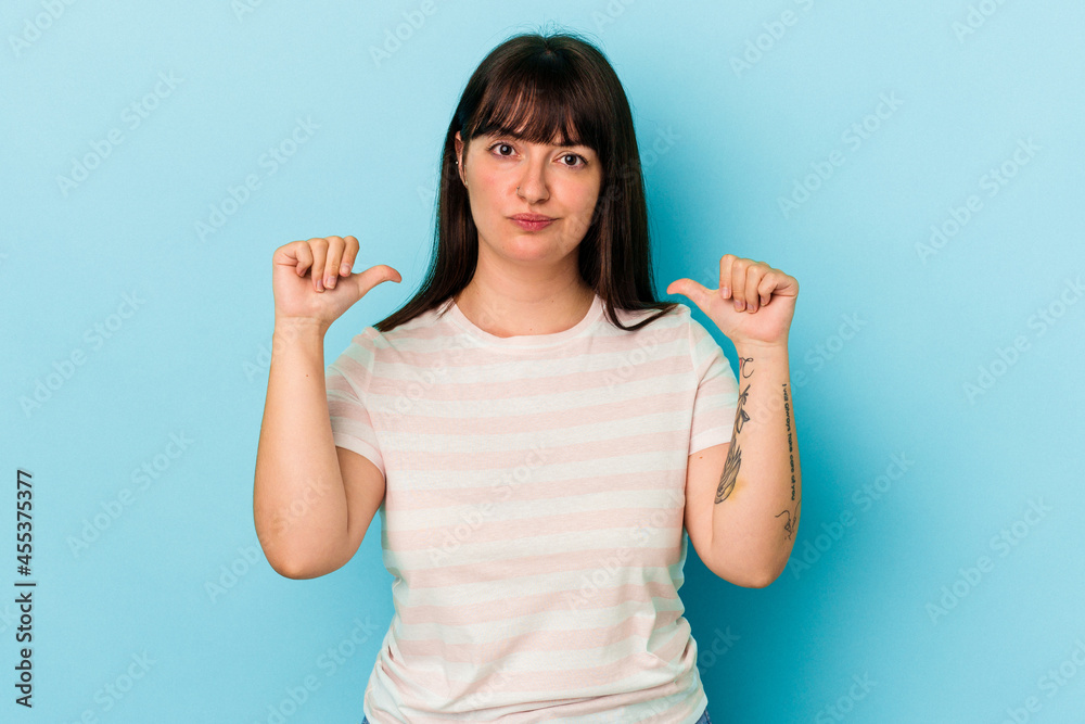 Young curvy caucasian woman isolated on blue background feels proud and self confident, example to follow. Young curvy caucasian woman isolated on blue background feels proud and self confident, example to follow.
