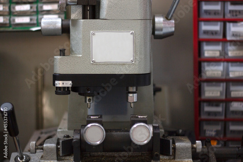 Картината върху платно Grey key duplicating machine in a hardware store with key boxes in the background