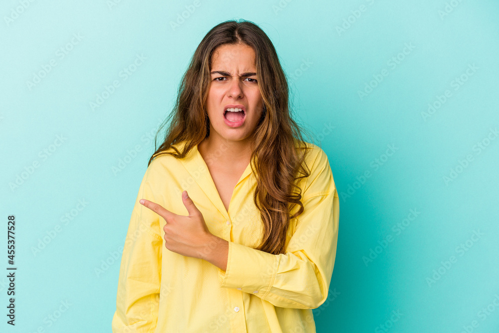 Young caucasian woman isolated on blue background pointing to the side Young caucasian woman isolated on blue background pointing to the side