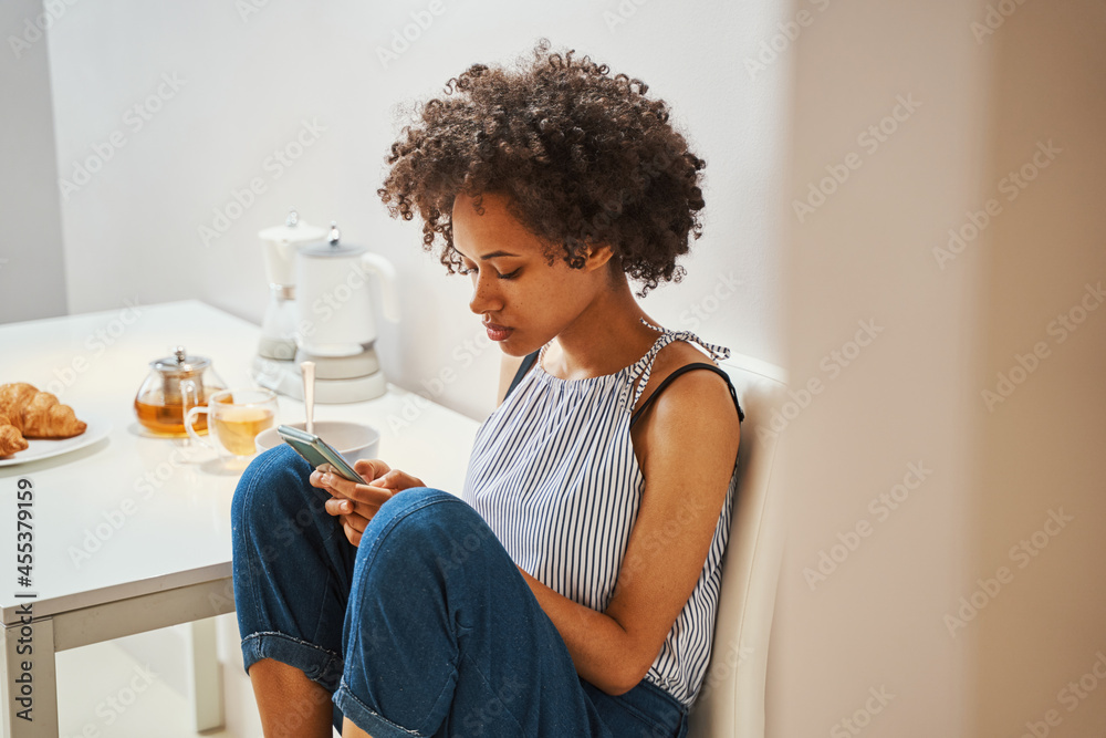 Woman surfing the Internet on her gadget during the morning meal Woman surfing the Internet on her gadget during the morning meal