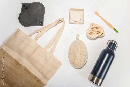 Artículos ecológicos sobre fondo blanco. Tote bag, botella de agua de acero inoxidable, esponja de lufa, compresa menstrual reutilizable, champú sólido, cepillo de dientes de bambú photo