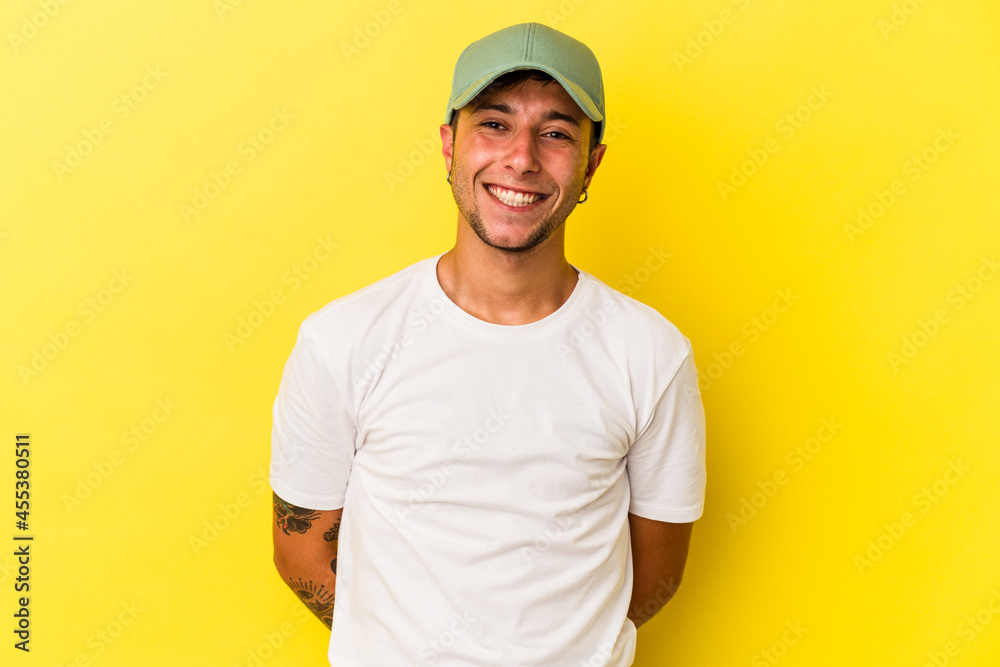 Young caucasian man with tattoos isolated on yellow background  happy, smiling and cheerful.