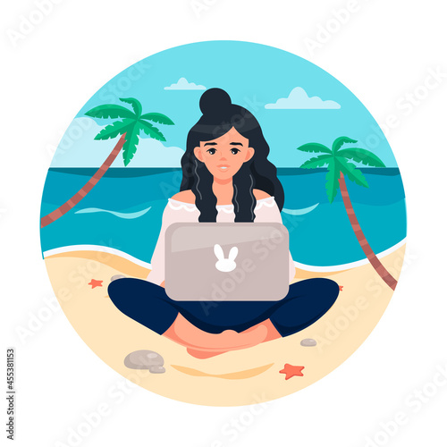 A young girl in the lotus position is working at a computer on the beach