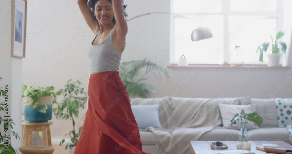 happy african american woman dancing at home wearing beautiful red dress celebrating having fun enjoying summer feeling confident 4k footage