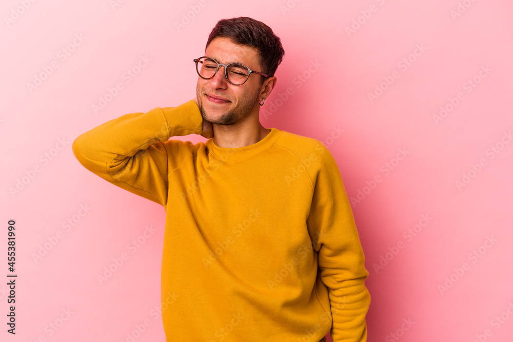 Young caucasian man with tattoos isolated on yellow background having a neck pain due to stress, massaging and touching it with hand. Young caucasian man with tattoos isolated on yellow background having a neck pain due to stress, massaging and touching it with hand.