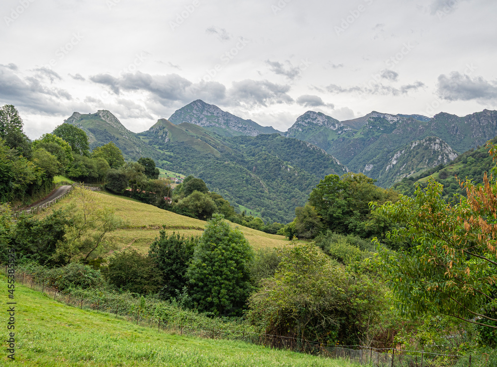 Panorámica un camino entre montañas y árboles verdes en el pueblo de Cazo, en Cantabria, España, verano de 2020