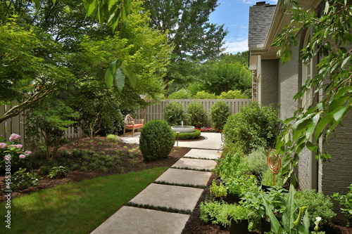 Slika na platnu Stone path in garden leading to backyard water fountain and patio