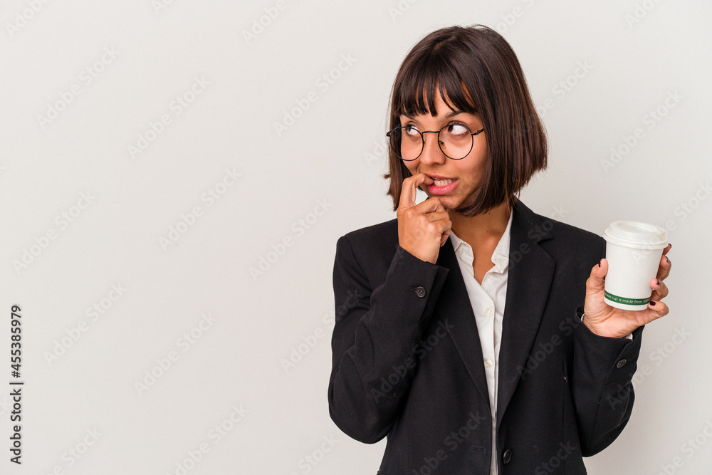 Young mixed race business woman holding a coffee isolated on white background relaxed thinking about something looking at a copy space. Young mixed race business woman holding a coffee isolated on white background relaxed thinking about something looking at a copy space.