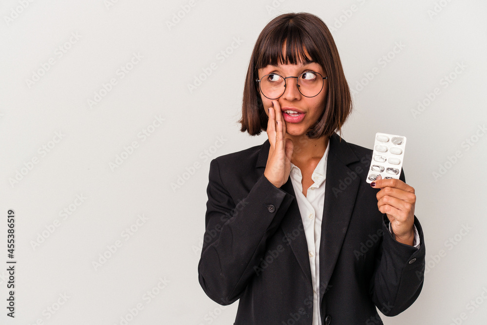 Young mixed race business woman holding pills isolated is saying a secret hot braking news and looking aside Young mixed race business woman holding pills isolated is saying a secret hot braking news and looking aside