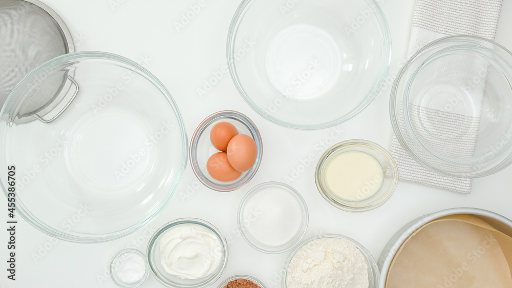 Ingredients and dishes for making cake close up on kitchen table, view from above. Step by step chocolate cake recipe, white kitchen table background Ingredients and dishes for making cake close up on kitchen table, view from above. Step by step chocolate cake recipe, white kitchen table background