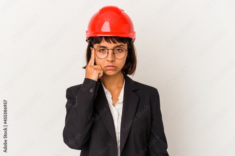 Young architect woman with red helmet isolated on white background pointing temple with finger, thinking, focused on a task. Young architect woman with red helmet isolated on white background pointing temple with finger, thinking, focused on a task.