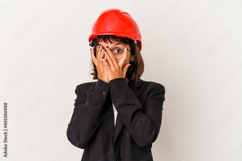 Young architect woman with red helmet isolated on white background blink through fingers frightened and nervous. Young architect woman with red helmet isolated on white background blink through fingers frightened and nervous.