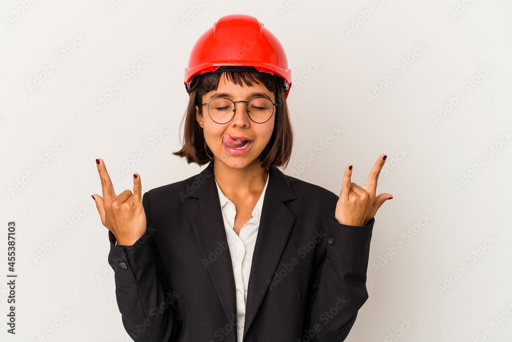 Young architect woman with red helmet isolated on white background showing rock gesture with fingers Young architect woman with red helmet isolated on white background showing rock gesture with fingers