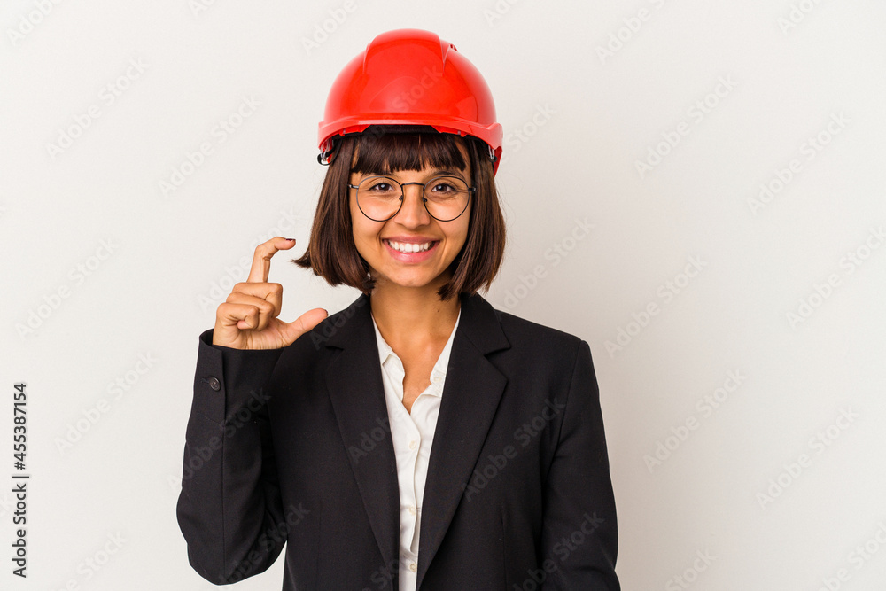 Young architect woman with red helmet isolated on white background holding something little with forefingers, smiling and confident. Young architect woman with red helmet isolated on white background holding something little with forefingers, smiling and confident.