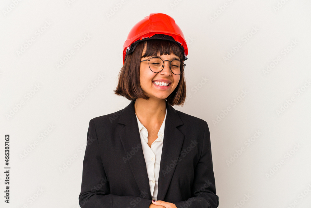 Young architect woman with red helmet isolated on white background relaxed and happy laughing, neck stretched showing teeth. Young architect woman with red helmet isolated on white background relaxed and happy laughing, neck stretched showing teeth.