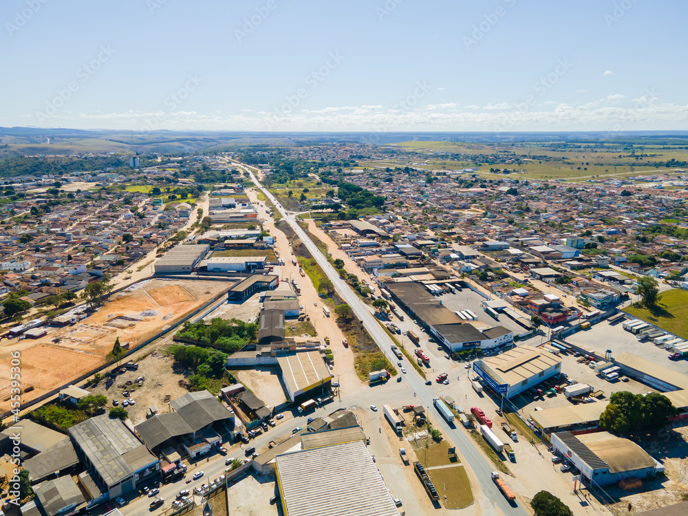 Visão aérea da região central da cidade de Texeira de Freitas, com bairros residenciais,  aera industrial e comercial com a BR101 cruzando a cidade.