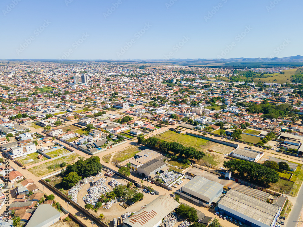 Visão aérea da região central da cidade de Texeira de Freitas, com bairros residenciais,  aera industrial e comercial com a BR101 cruzando a cidade.