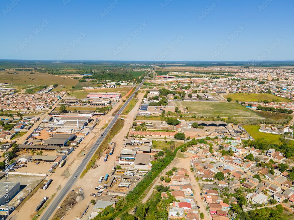 Fototapeta premium Visão aérea da região central da cidade de Texeira de Freitas, com bairros residenciais, aera industrial e comercial com a BR101 cruzando a cidade.