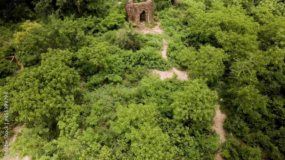 Angkor Temple, Phnom Kambot Temple. Remote red brick hillside towers in the Cambodian countryside surrounded by green trees waving in the wind, Drone birds-eye fly over. Forgotten temples Cambodia. Angkor Temple, Phnom Kambot Temple. Remote red brick hillside towers in the Cambodian countryside surrounded by green trees waving in the wind, Drone birds-eye fly over. Forgotten temples Cambodia.