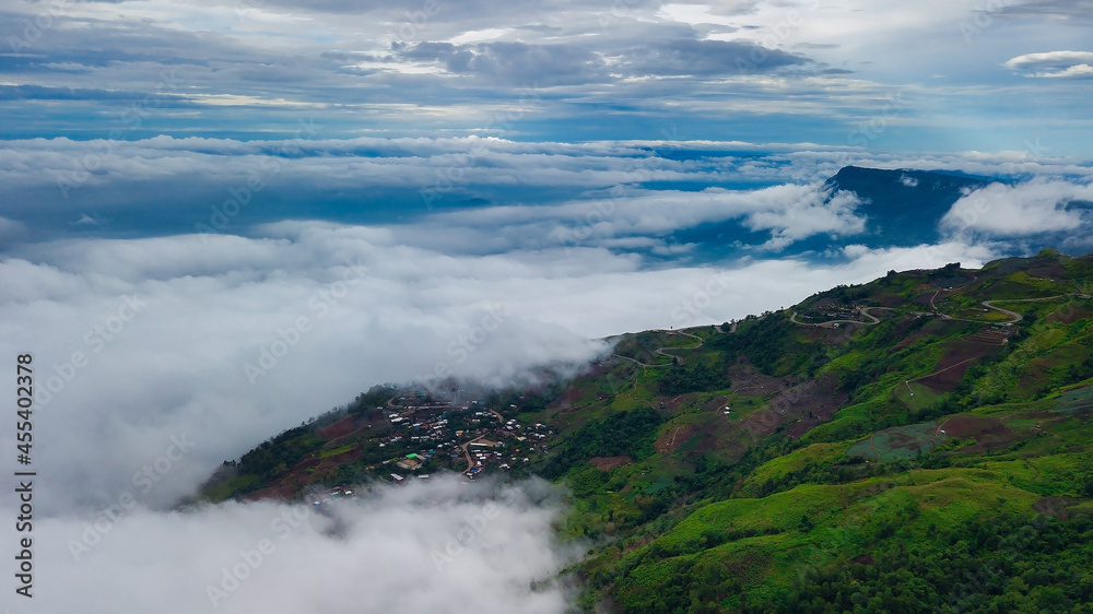 View of the long road up to the hill with green grass, forest, mountain and blue sky background, Phu Thap Boek, Phetchabun Province, Thailand