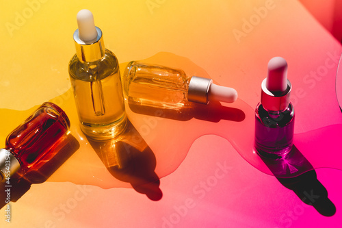 Dropper glass bottles with pipette. Transparent hyaluronic natural beauty mineral product and eco serum skin care concept. Top horizontal view copyspace. Summer juicy colors