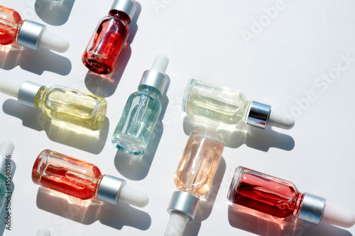 Dropper glass bottles with pipette. Transparent hyaluronic natural beauty mineral product and eco serum skin care concept. Top horizontal view copyspace. Summer juicy colors