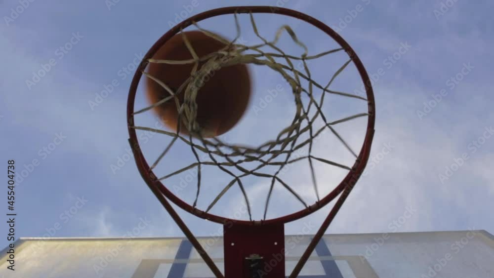 Person Shoots Ball Into The Basket And Get Stuck In An Outdoor Playground. - Low Angle Person Shoots Ball Into The Basket And Get Stuck In An Outdoor Playground. - Low Angle