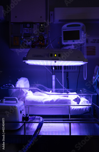 Newborn baby with jaundice lays in Phototherapy bed