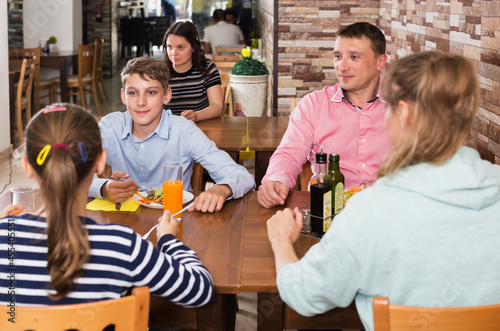 Glad family having conversation at dining table in cafe