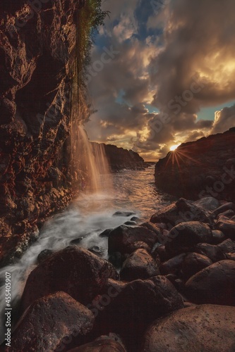 The sun is setting at a small cave by Queens Baths on the north shore of Kaua'i.