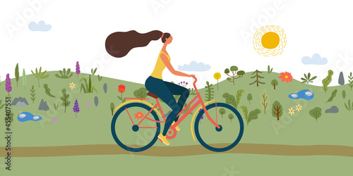Girl riding bicycle. Park. meadow and hills on background