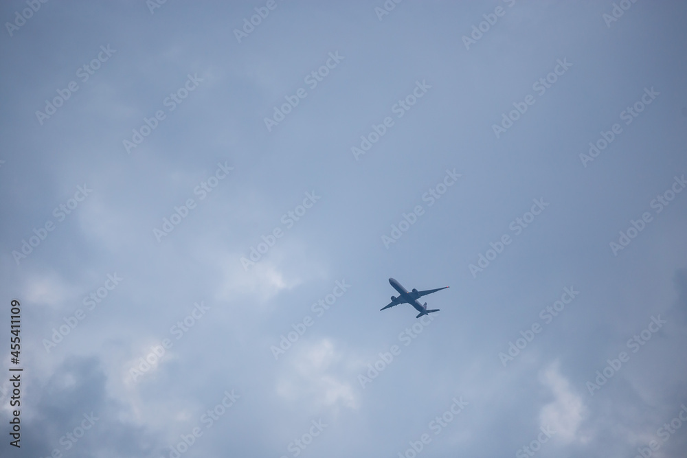 A passenger plane takes off against the background of a cloudy sky at sunset.
