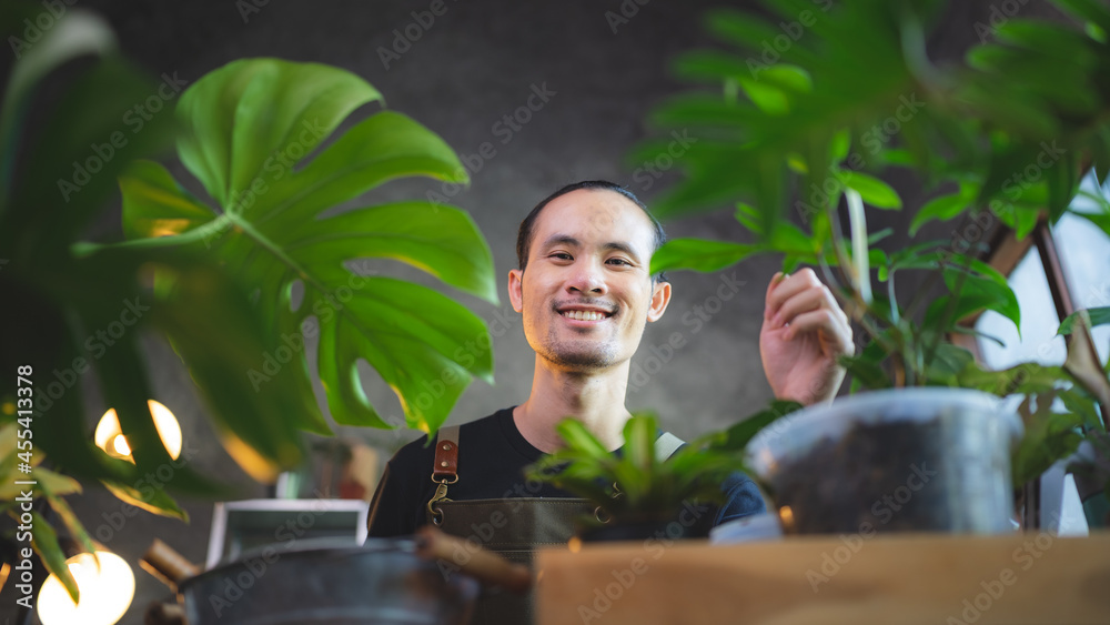 young Asian man are happy with growing plant in small green garden at home, hobby lifestyle with green nature in a house, flower tree in pot botanical gardening agriculture cultivation young Asian man are happy with growing plant in small green garden at home, hobby lifestyle with green nature in a house, flower tree in pot botanical gardening agriculture cultivation