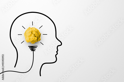 Creative thinking ideas and innovation concept. Paper scrap ball yellow colour with light bulb and head human symbol on white background