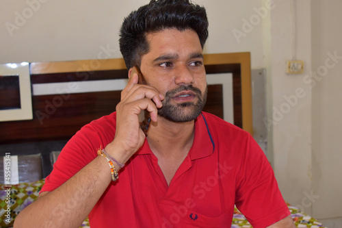 An Indian man talking on a cell phone at home