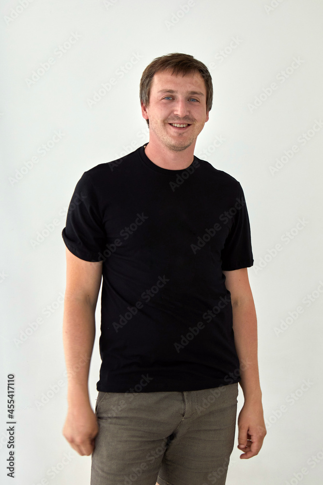 Young male model wearing basic black t shirt with space for print standing against white background Young male model wearing basic black t shirt with space for print standing against white background
