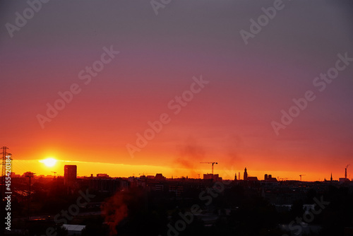 Sunset over city with buildings silhouette