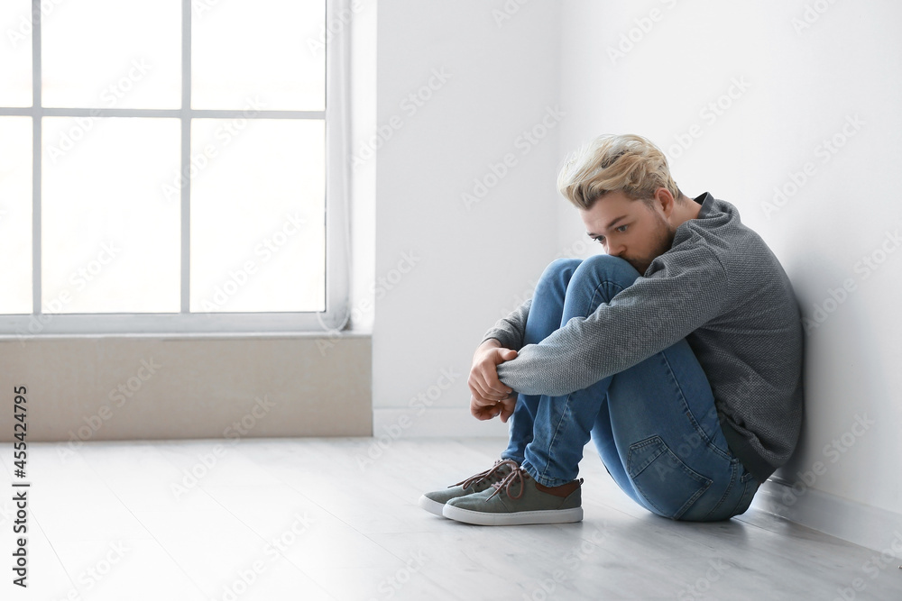 Depressed young man in empty room Depressed young man in empty room