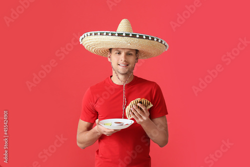 Young Mexican man eating ta...