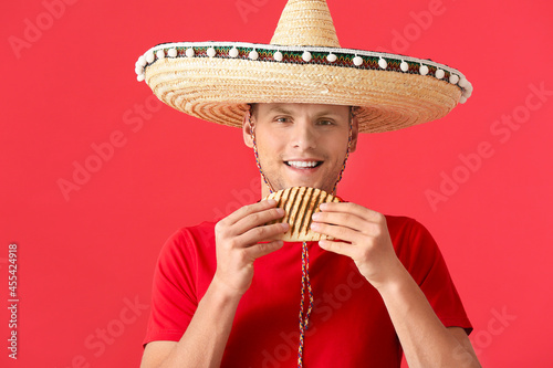 Young Mexican man eating ta...