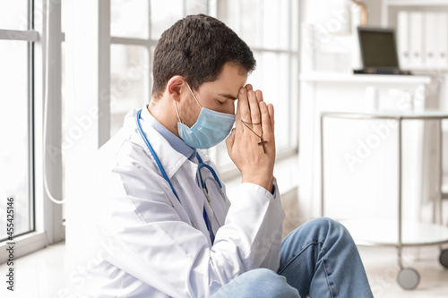 Religious doctor praying in...