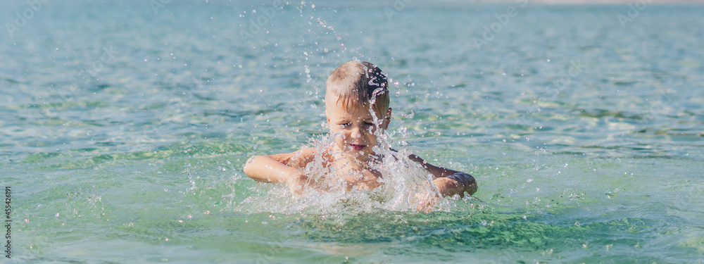 BANNER lifestyle stock photo boy swim do motion frolics fun splashing water sea. Summer sun nature landscape. Happy childhood, travel vacation with kid children, leisure activity, simple fun behavior