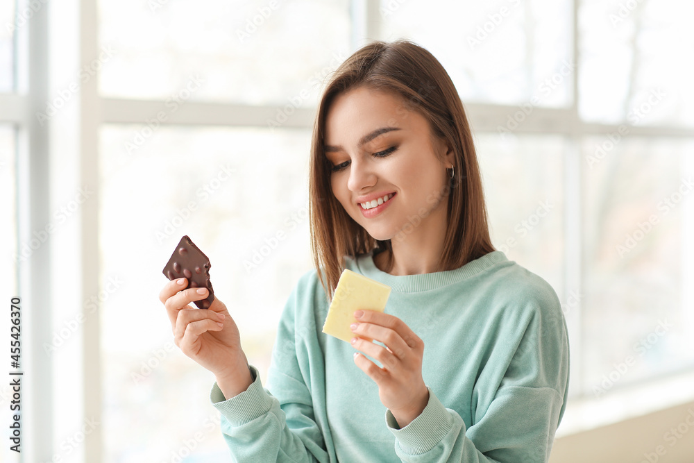 Beautiful young woman with tasty chocolate at home Beautiful young woman with tasty chocolate at home