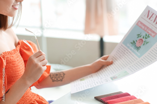 Young woman reading newspap...