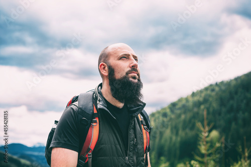 Hiker with backpack. Handsome bearded caucasian man in the mountains.