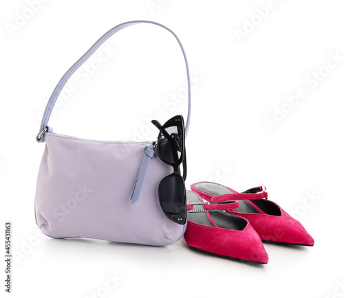 Stylish handbag, shoes and glasses on white background
