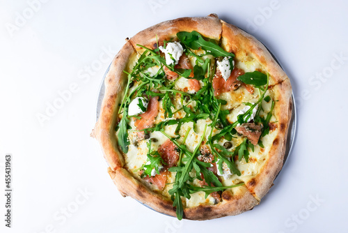 Pizza with mozzarella, salmon slices, fresh arugula. Isolated on white background. Italian cuisine concept