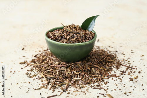Bowl of dry hojicha green tea on light background